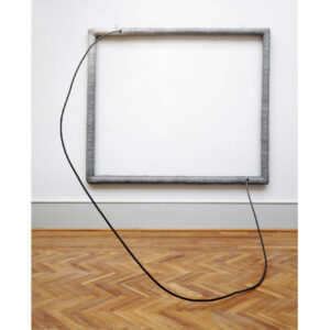 Photo of Eva Hesse's sculpture, Hang Up, of 1966 made of cloth painted with grey acrylic over a rectangular wood frame. A steel wire exits from the upper left side and enters the lower right side.