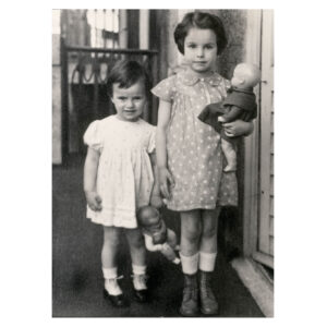 Black and white photo of Eva Hesse and her older sister, holding dolls.