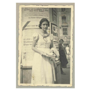Black and white photo of Lily Renée in the streets of Vienna, c. 1937, wearing a white dress.
