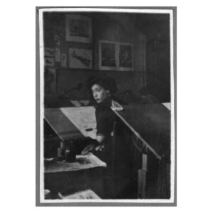 Black and white photo of Lily Renée on a desk at work at Fiction House (New York, 1940s).